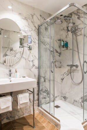 Habitación clásica doble | Baño | Cabezal de ducha tipo lluvia y artículos de higiene personal ecológicos