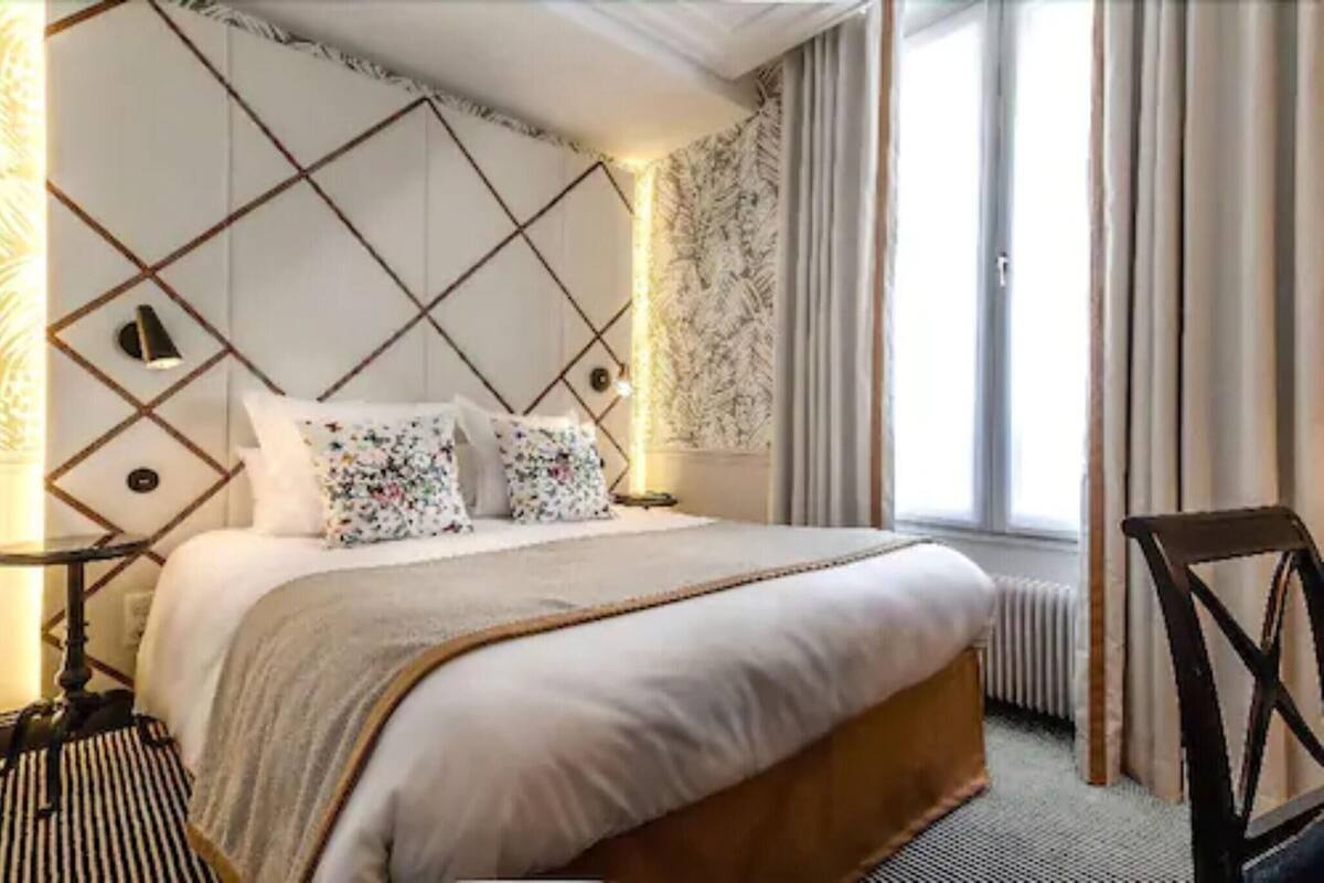 Senger med overmadrass, safe på rommet, skrivebord og blendingsgardiner