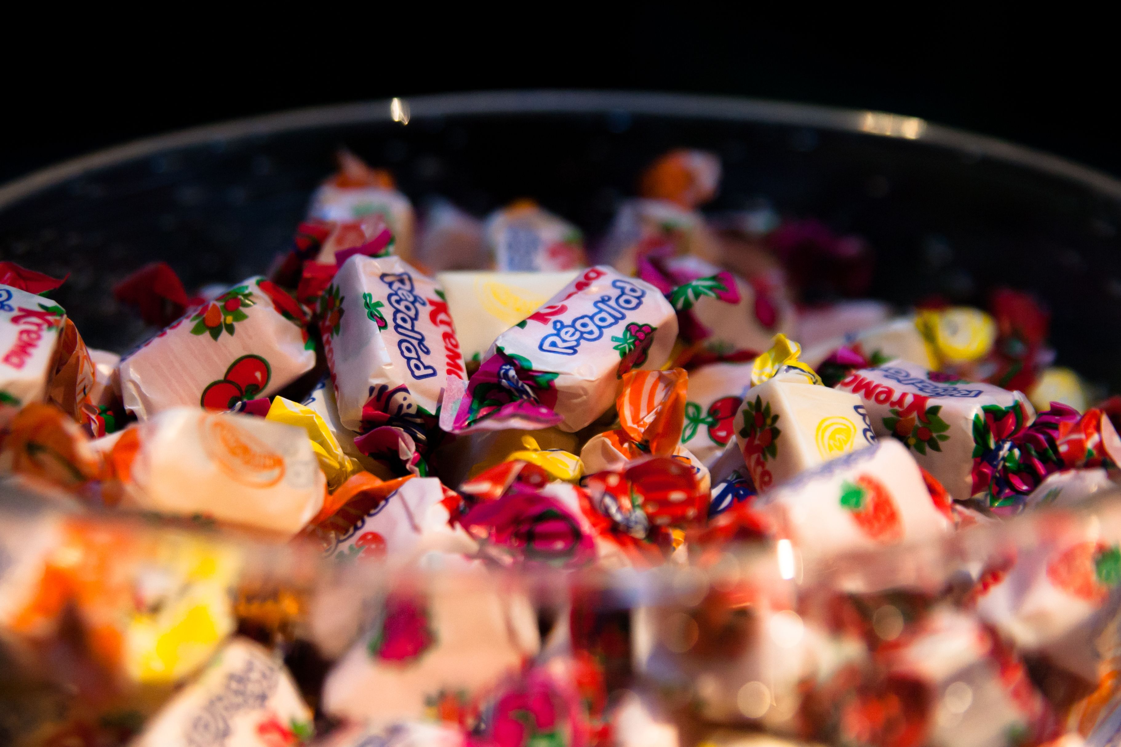 A bowl filled with assorted wrapped candies.