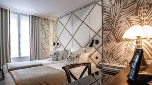 A hotel room with two beds, a large mirror, a desk with a lamp, and a telephone. - Hôtel Jardin le Bréa (Paris)