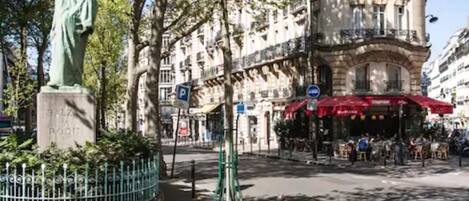 Una estatua en una plaza con un edificio al fondo.