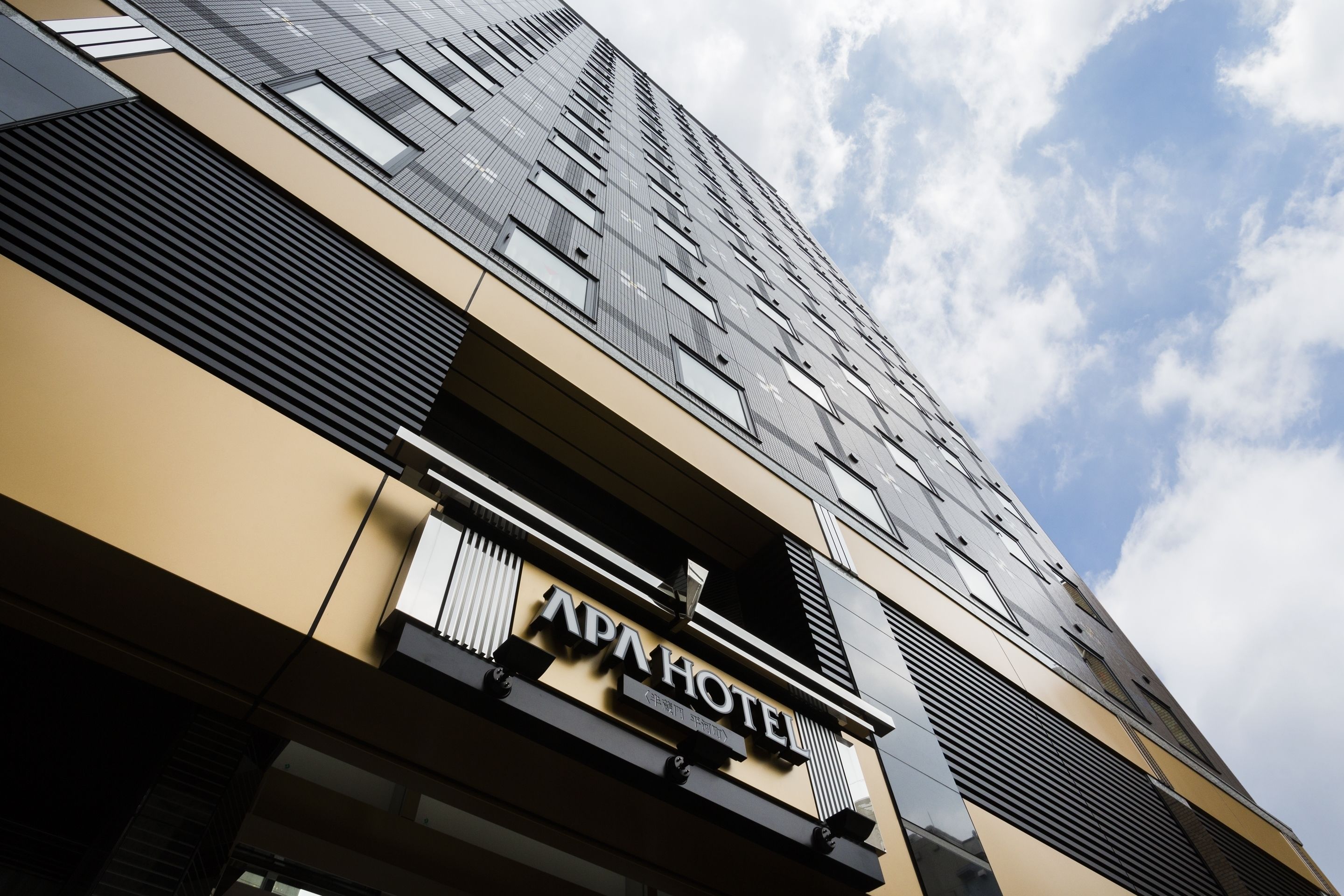 A modern hotel building with a prominent sign reading "APAHOTEL".