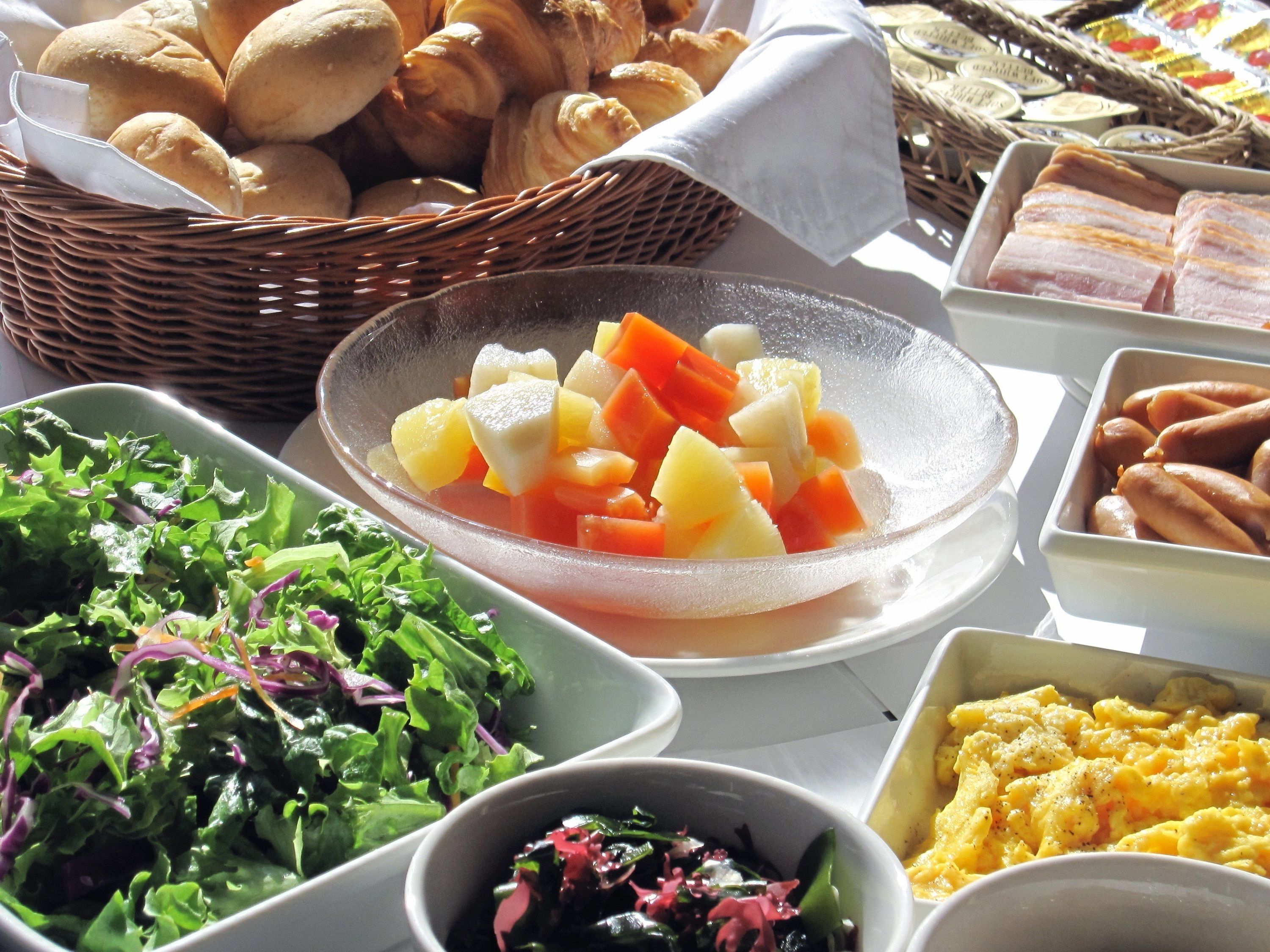 A table with various food items including bread, vegetables, and a salad.