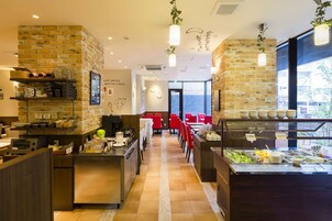 Un restaurante con paredes de ladrillo, un mostrador de buffet y sillas rojas.