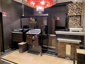 A hotel reception area with a digital check-in kiosk, a reception desk, and a chandelier. - APA Hotel Nagatacho Hanzomon Ekimae (Tokyo)