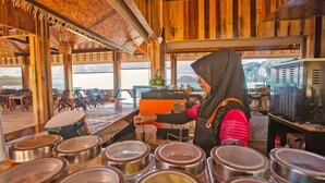 A wooden interior with a bar area, large windows, and a view of the sea. - Phi Phi Andaman Beach Resort (Ko Phi Phi)