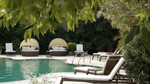 A poolside area with lounge chairs and a pool. - Hotel Rosamar (Calonge)