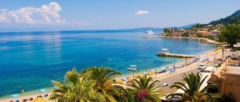 Ranta lähistöllä, aurinkotuoleja, aurinkovarjoja