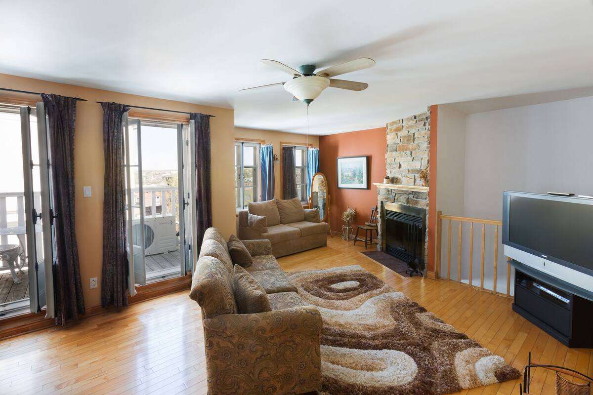 A living room with a sofa set, a television, and a fireplace.