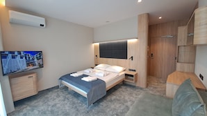 A modern hotel room with a bed, a TV, a wardrobe, and a bathroom. - Verano (Kolobrzeg)