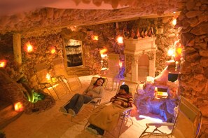 A stone-walled room with two reclining chairs and a fireplace. - Verano (Kolobrzeg)
