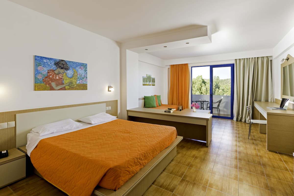 Une chambre d’hôtel équipée d’un lit, d’un bureau, d’une chaise et offrant une vue sur l’extérieur.