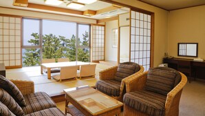 A traditional Japanese-style room with tatami flooring, low tables, and woven furniture.