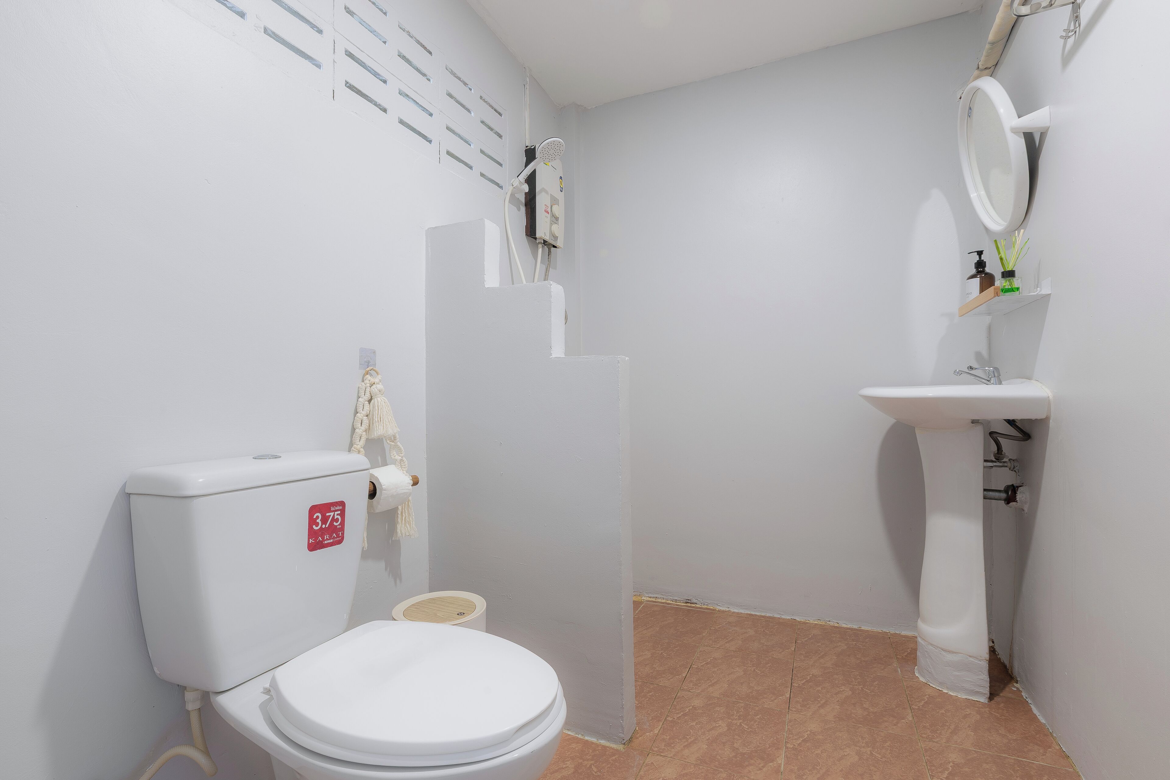 Un baño pequeño y limpio con inodoro, lavamanos y ducha.