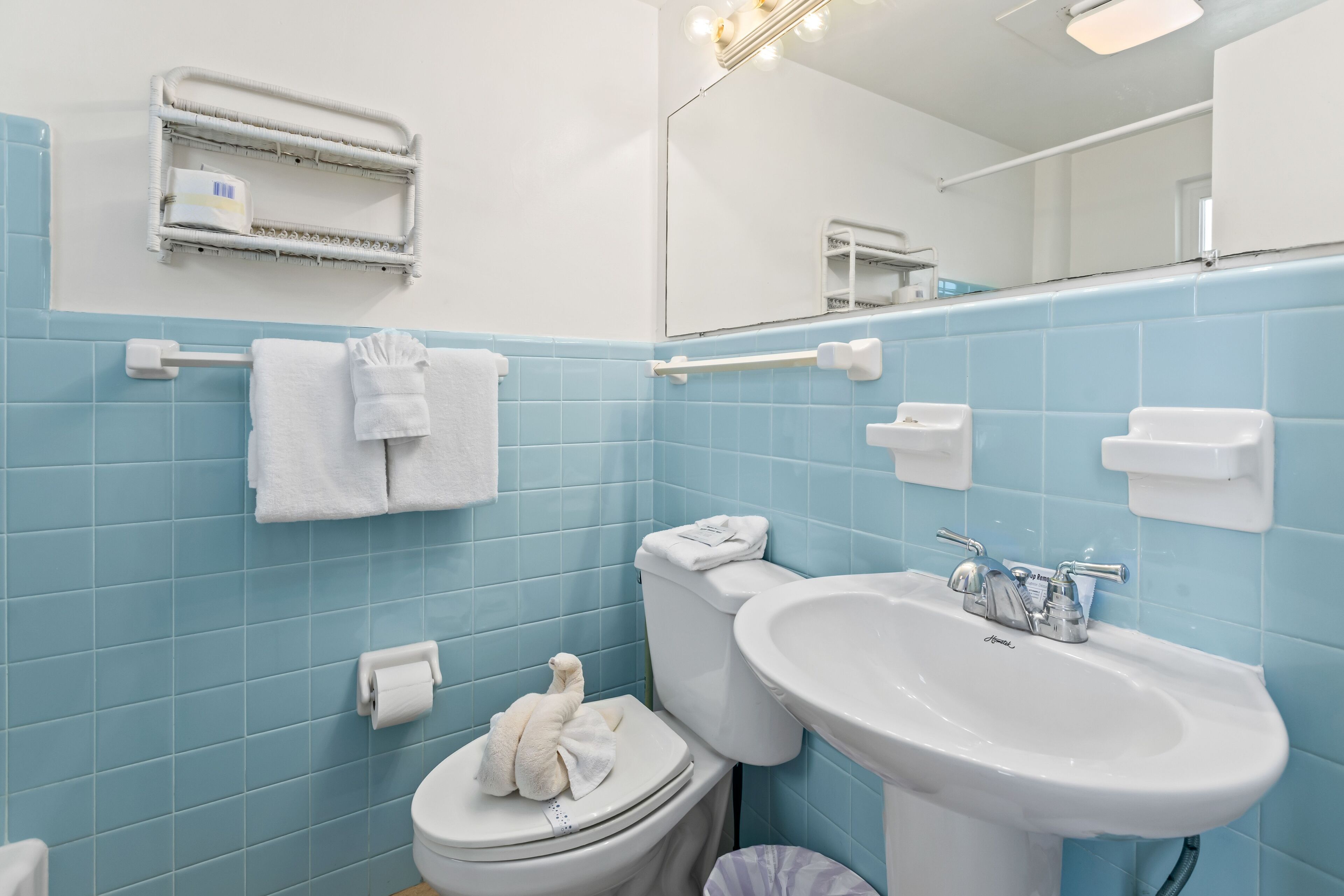 Ein Badezimmer mit Toilette, Waschbecken und blauen Fliesen.