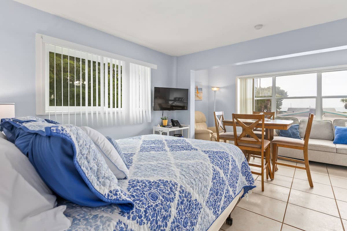 Ein Schlafzimmer mit Bett, Fernseher, Schreibtisch und Stuhl.