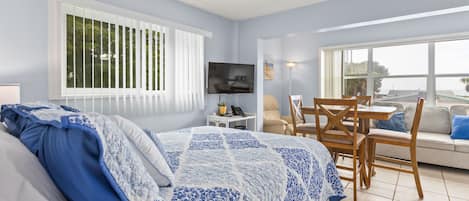 A bedroom with a bed, a TV, a desk, and a chair.