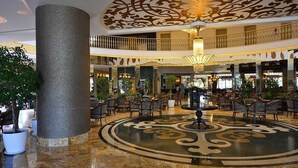 A spacious lobby with a large central column, ornate ceiling design, and multiple seating areas. - Side Crown Palace Ultra All Inclusive (Manavgat)