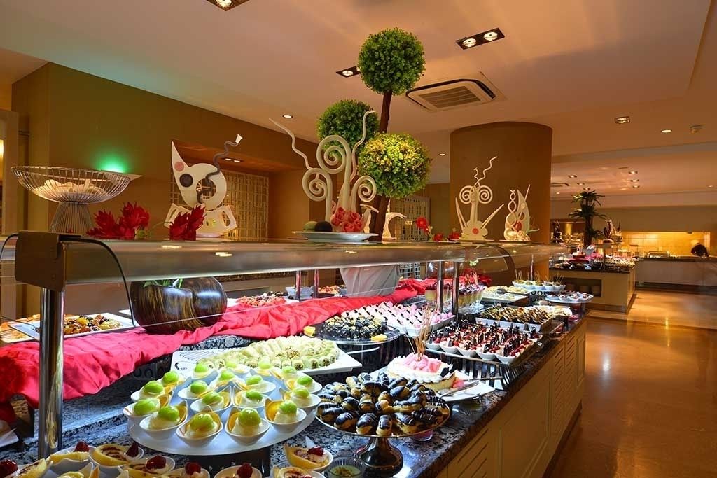 A buffet with various food items and decorative elements like a tree and abstract sculptures.