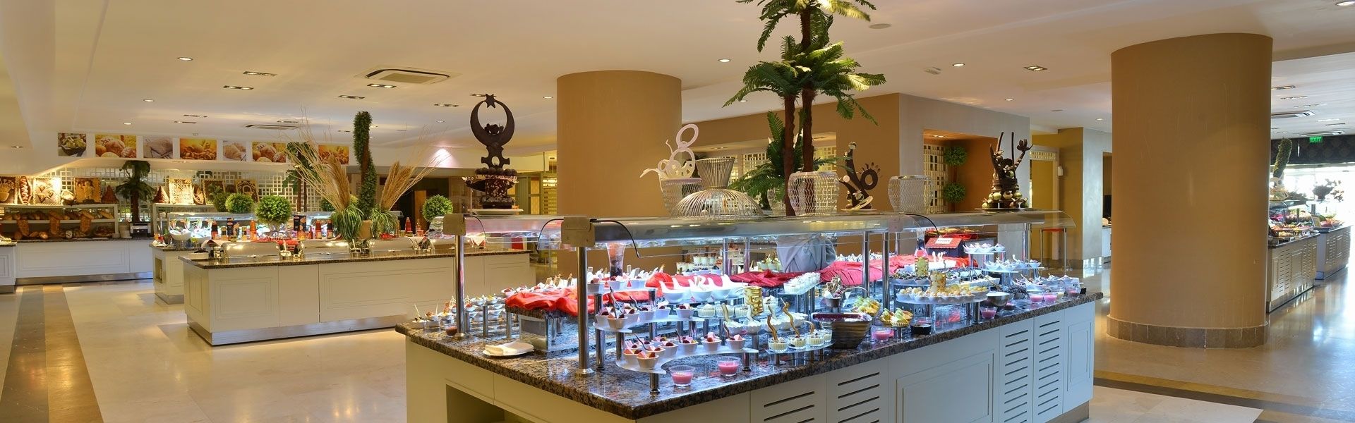 A buffet area with various food items and a decorative fountain.
