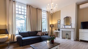 A living room with a sofa, a coffee table, a fireplace, and a television. - Bed & Breakfast Rijsterbosch (Rijs)