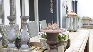A wooden table with wicker baskets and a rustic urn. - Bed & Breakfast Rijsterbosch (Rijs)