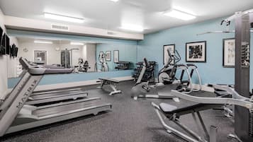Une salle de sport équipée de tapis de course, de vélos elliptiques et de bancs de musculation.