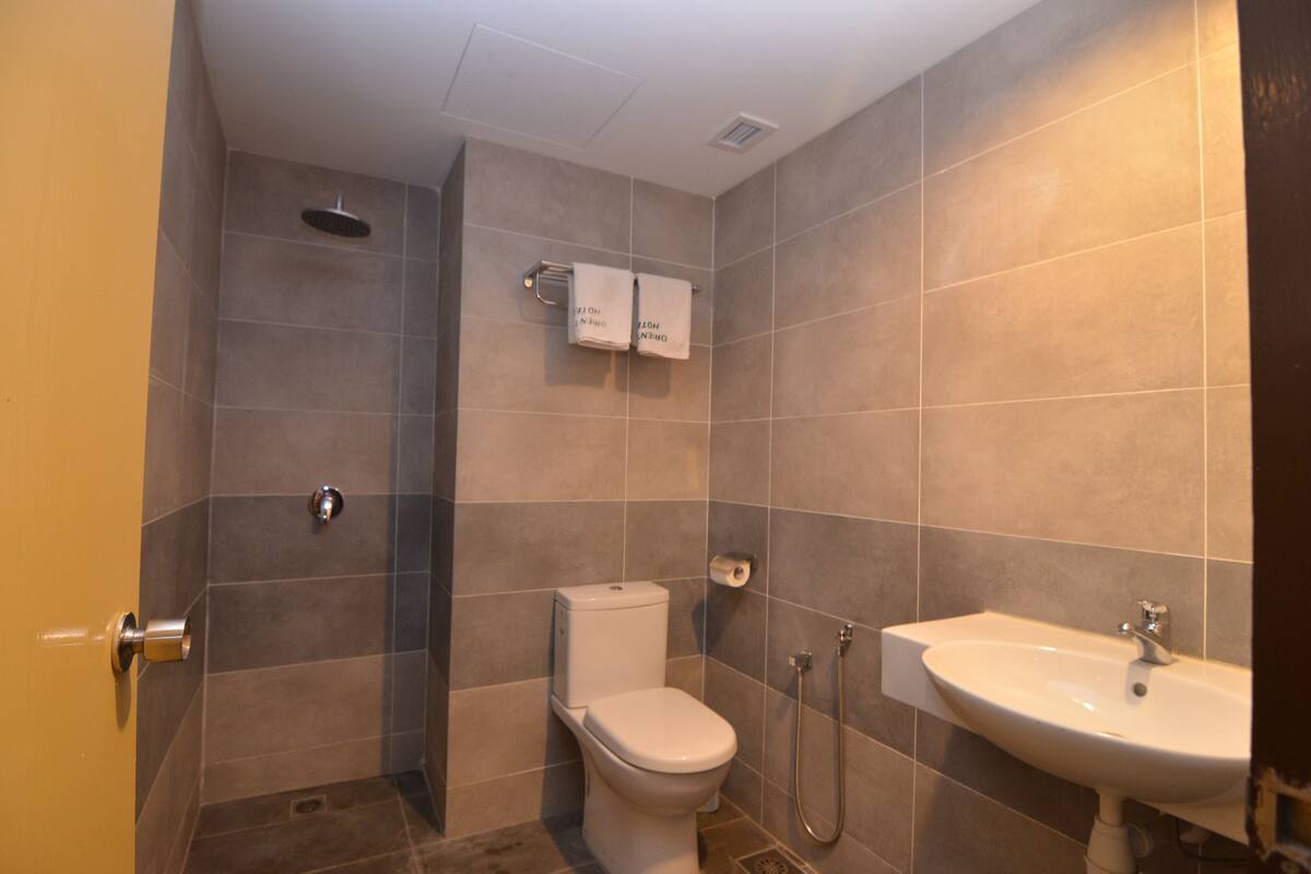 A bathroom with a toilet, shower, and sink.