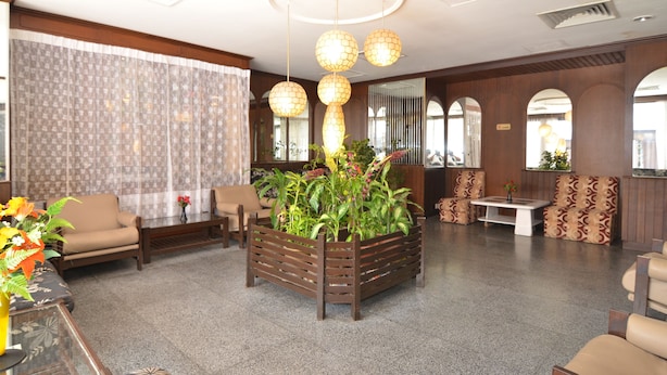 A lobby with seating areas, a central plant display, and a ceiling with spherical light fixtures. - Oriental Hotel (George Town)