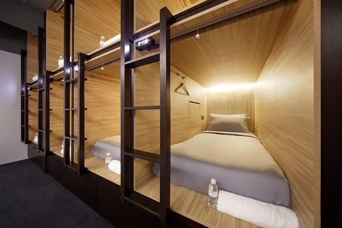 A compact, wood-paneled room with a bunk bed and a small desk area.