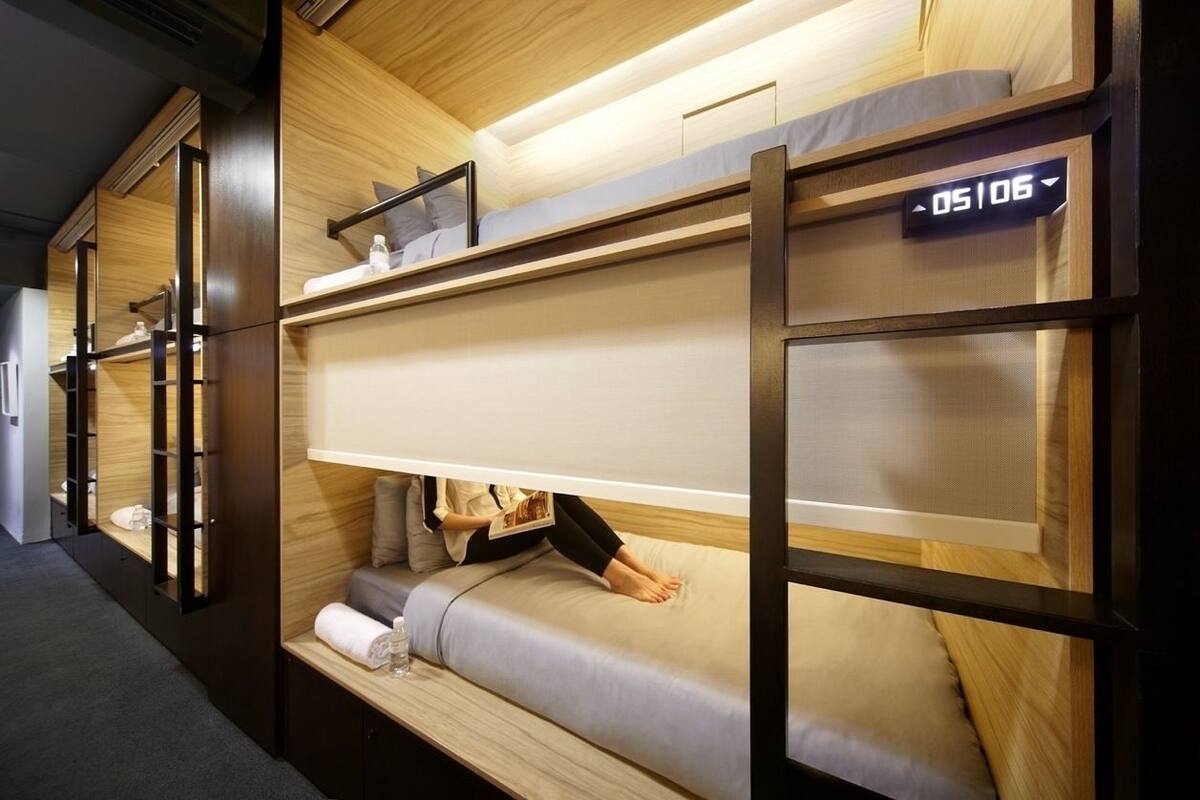 A bunk bed room with a digital clock displaying 05:06.