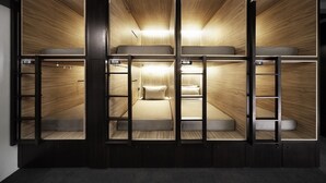 Habitación con literas compactas de varios niveles, almacenaje integrado y escalera.