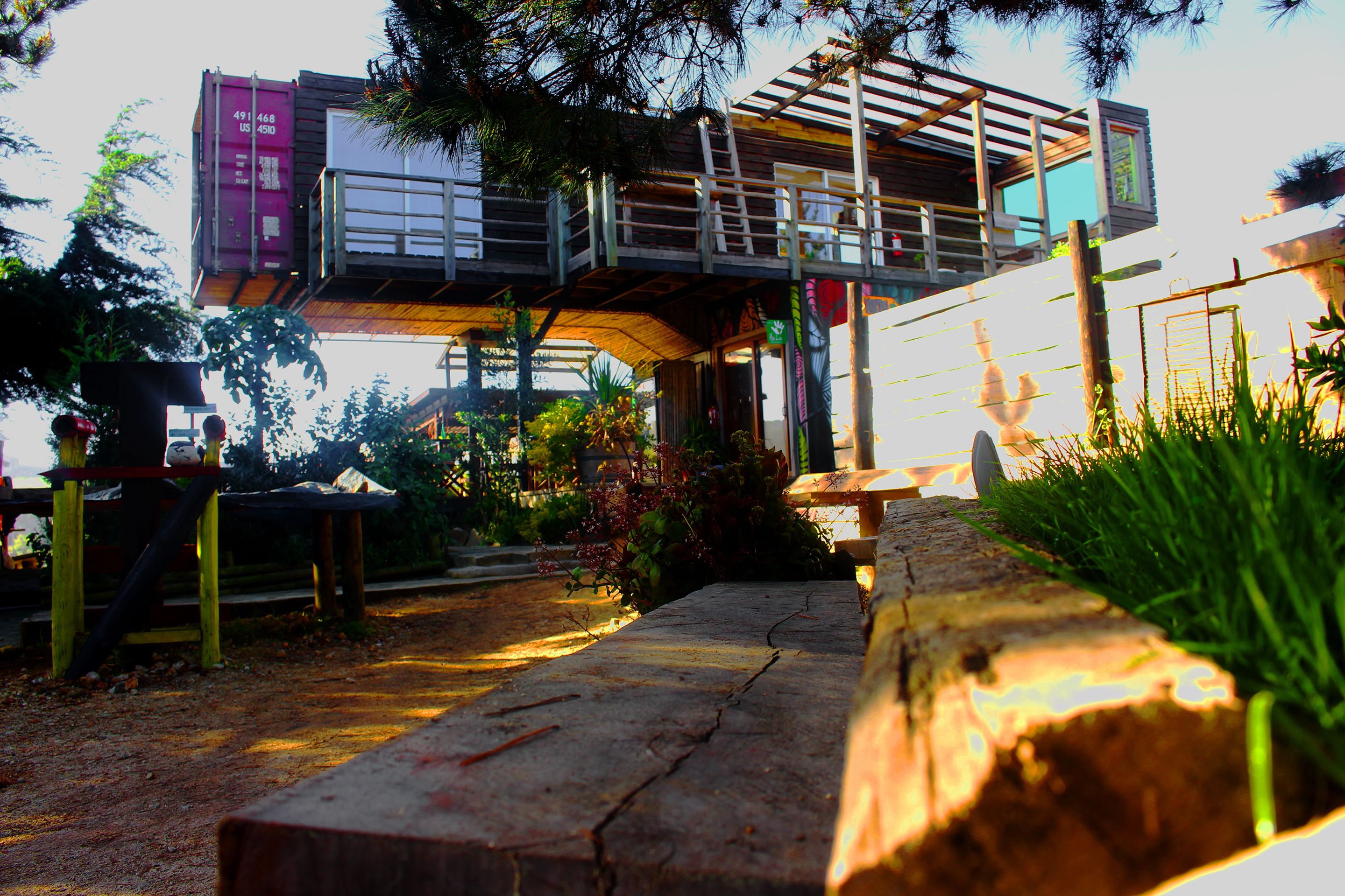 A multi-level outdoor structure with a wooden deck and a metal staircase.