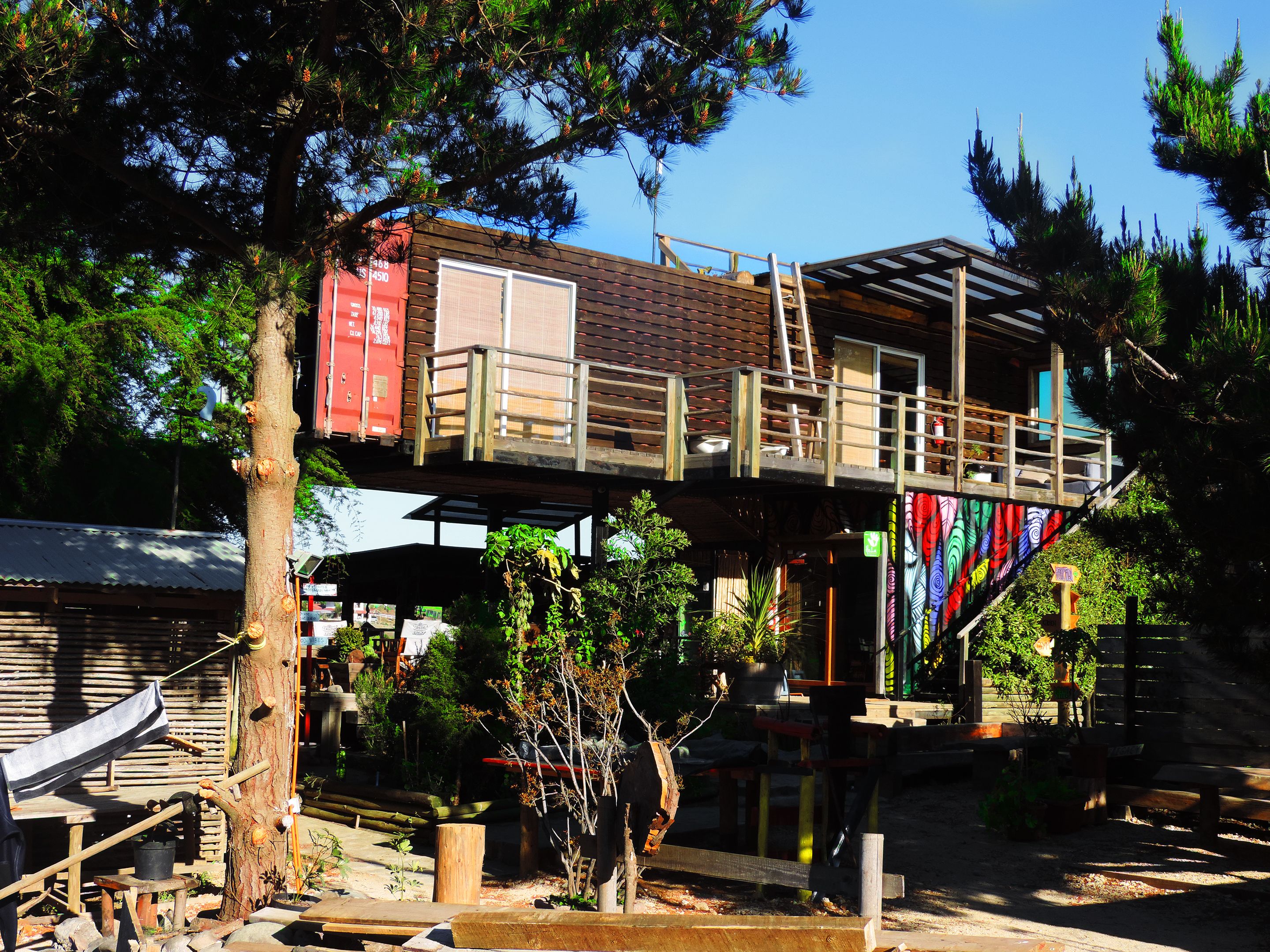 A rustic cabin with a wooden deck and a small balcony.
