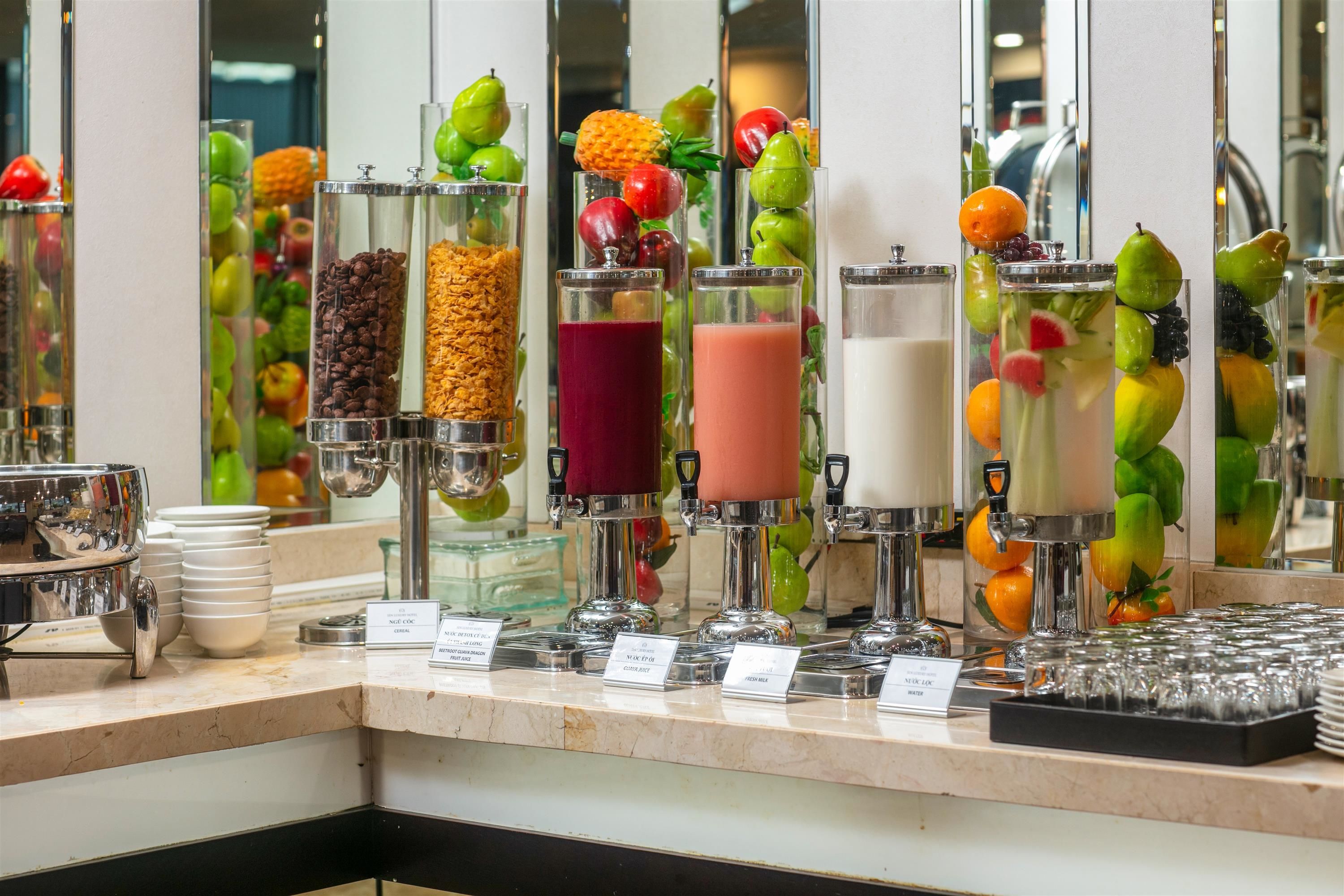 A beverage station with various drink dispensers, including options for coffee, cereal, fruit juice, and milk.