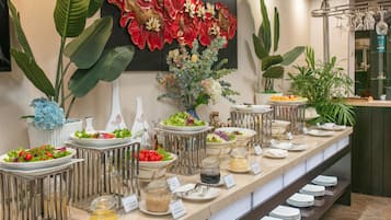 A buffet setup with various food options and a decorative wall.