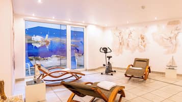 A room with a large window, exercise equipment, and a mural.