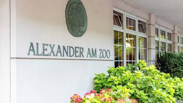 Das Außengelände eines Gebäudes mit der Aufschrift 'ALEXANDER AM ZOO', das als Zoo gekennzeichnet ist.