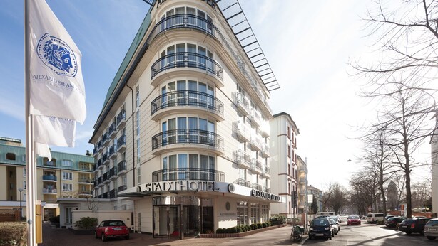 A multi-story hotel with a curved facade, balconies, and a prominent sign reading "ALEXANDER AM ZOO". - Hotel Alexander am Zoo (Frankfurt)