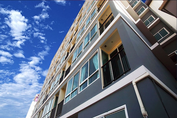 A multi-story hotel with a modern architectural design, featuring balconies and large windows.