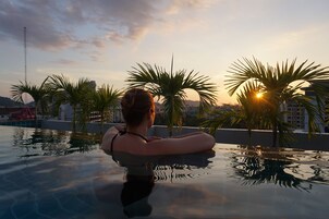 Una piscina al aire libre, sillones reclinables de piscina