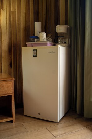 A compact kitchenette with a refrigerator, coffee maker, and a small table. - Brisas Arenal Hotel (La Fortuna)