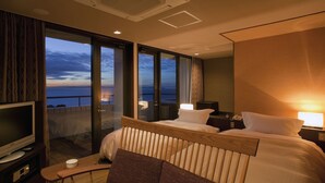 A hotel room with a bed, bedside tables, a TV, and a balcony with a view of the sea. - Shimahana (Sumoto)