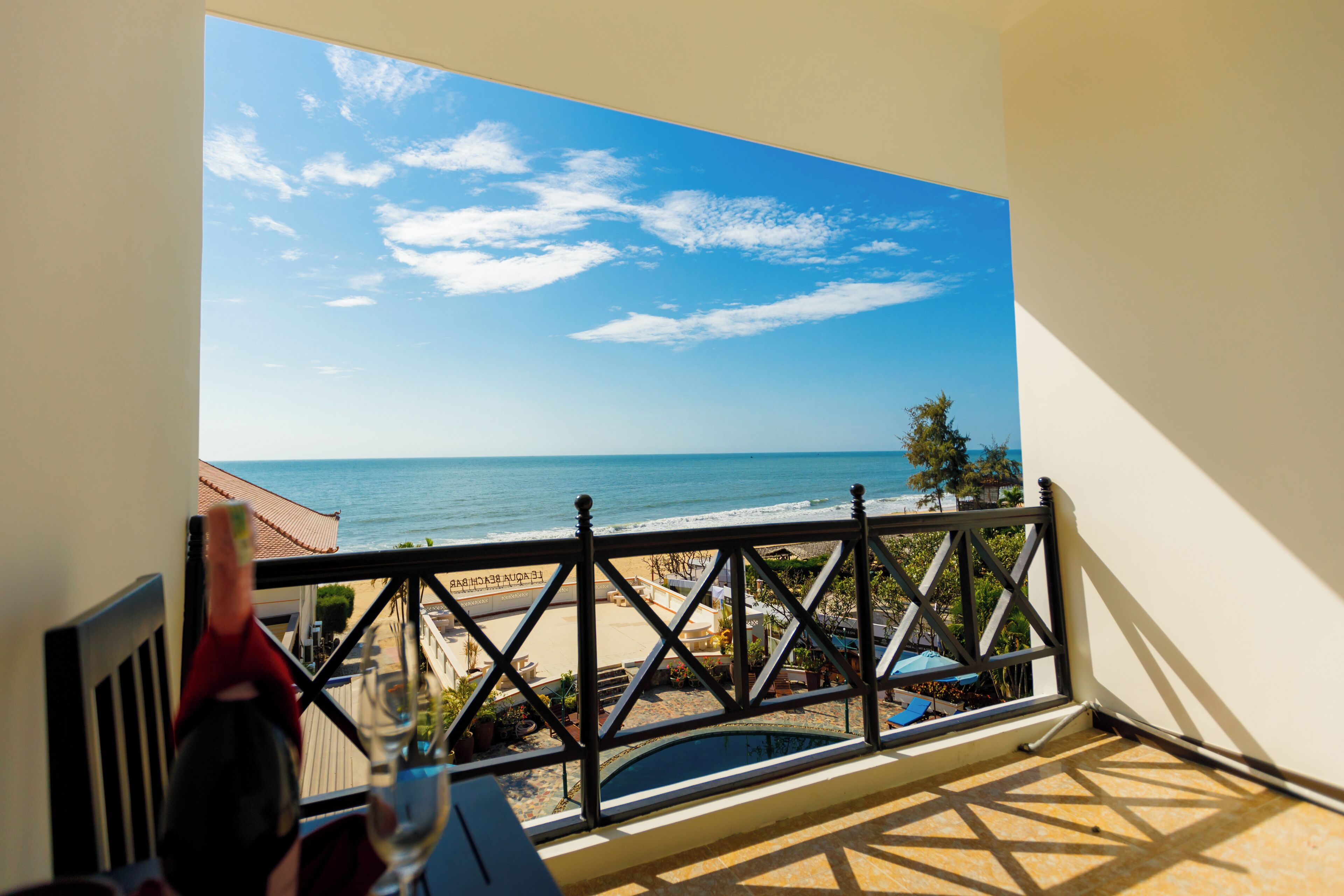 A balcony with a view of the beach and ocean.