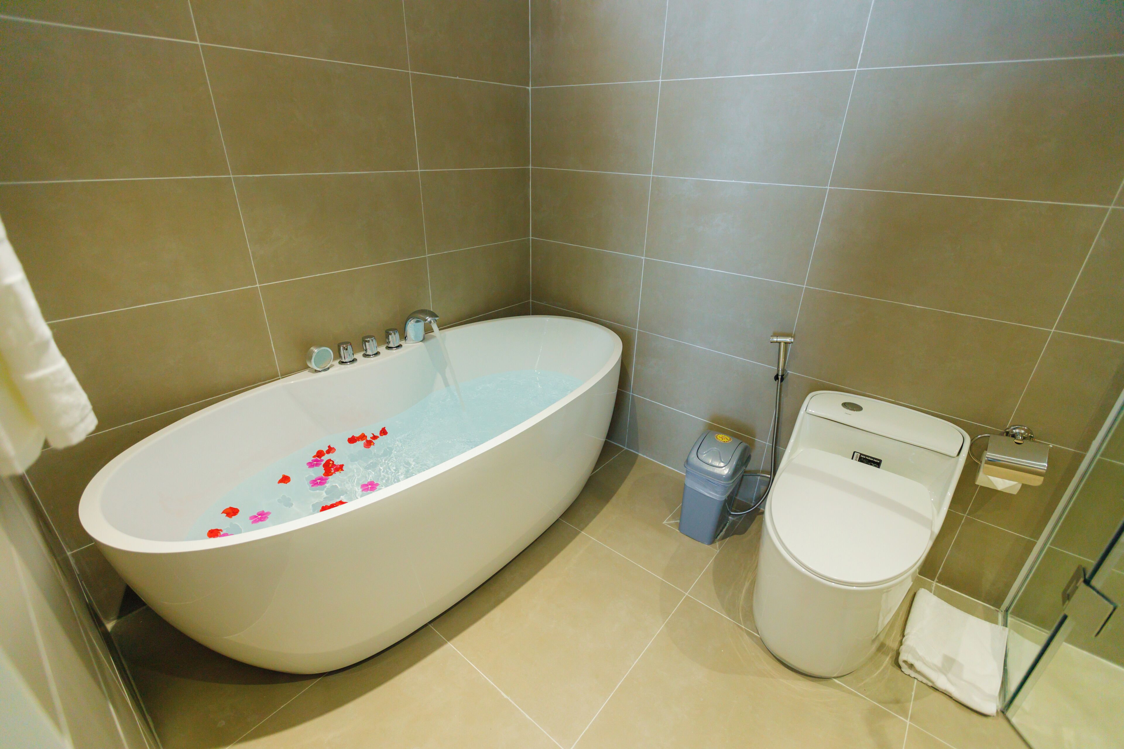 Ein Badezimmer mit Badewanne, Toilette und Mülleimer.