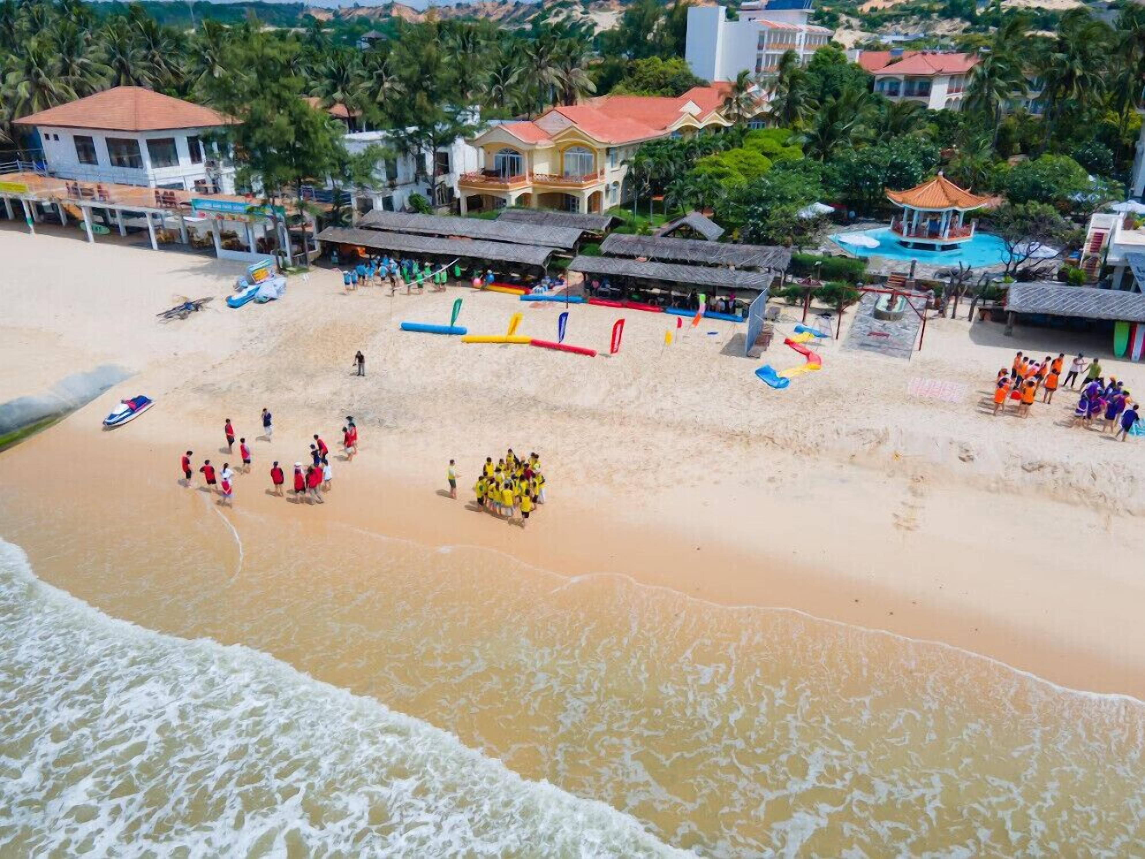 A beach with a swimming area, a lifeguard tower, and several buildings in the background.