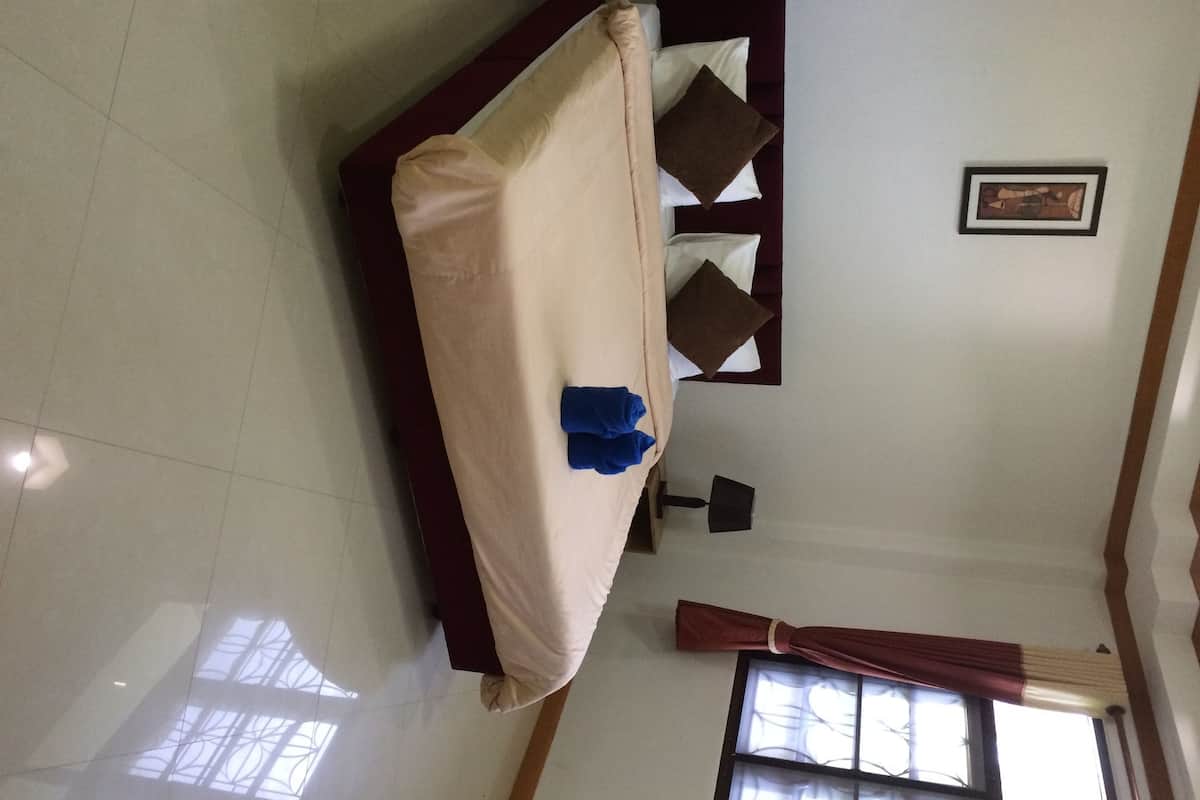 Una habitación con cama, ventana con cortinas, un cuadro en la pared y piso de baldosas.