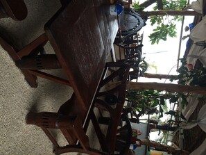 A rustic wooden chair with a metal frame, a wooden table, and a decorative wheel. - Haad Yao Villa (Ko Pha-ngan)