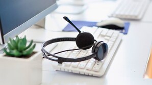 A headset on a desk with a keyboard and a small potted plant. - Holiday Inn Express Fort St John by IHG (Fort St. John)