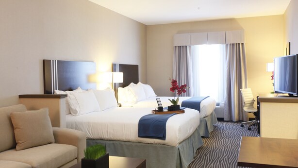 A hotel room with a large bed, a sofa, a desk, and a television. - Holiday Inn Express Fort St John by IHG (Fort St. John)